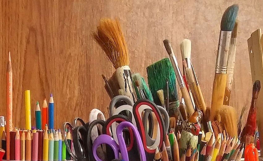 Pennor, saxar och målarpenslar i olika färger.