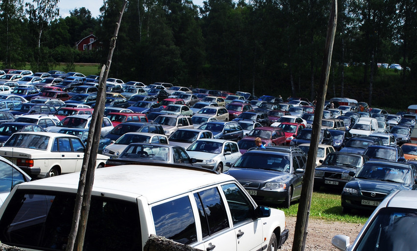 Många bilar på en tillfällig bilparkering. Bilarna står på en stor gräsmatta när Bjuråkerstämman drar igång.