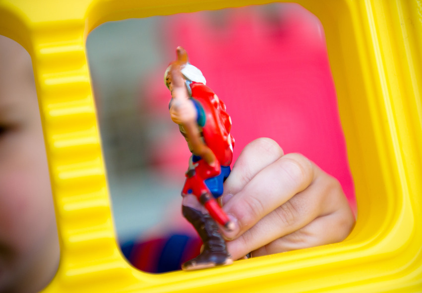 Barnhand som håller i leksaksfigur i plast