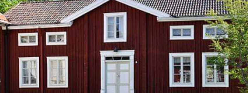 Njutångers sockens hembygdsförening, byggnaden är röd med vita knutar med en intilliggande vit byggnad i nittio graders vinkel.