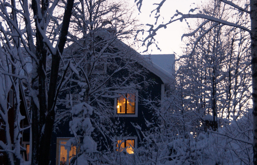 Hus med lampor tända på vintern.