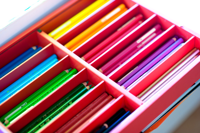 En låda med olika fack. I facken ligger pennor uppdelade efter färg.