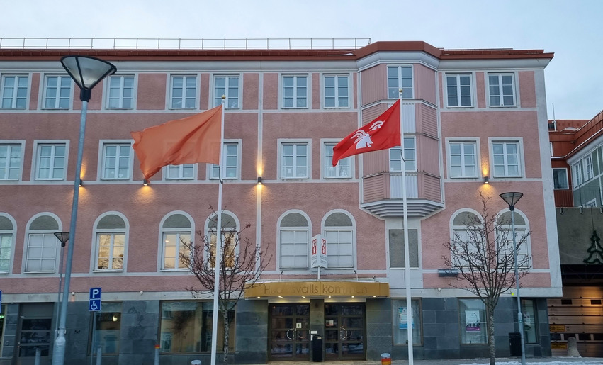 Orange flagga vajar bredvid Hudiksvalls kommuns flagga framför kommunhuset.