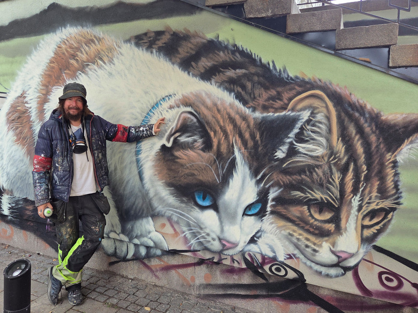 Charlie Granberg framför en muralmålning i Hudiksvall