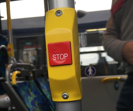 Bild inifrån en buss på en stopp-knapp.