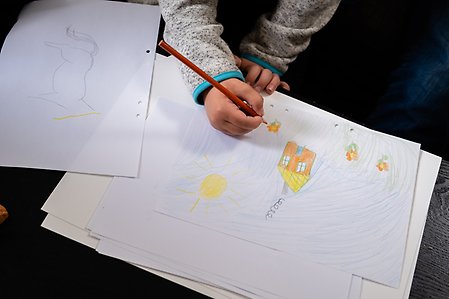 Ett barn ritar en teckning.