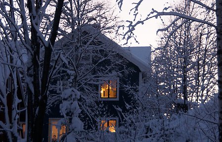 Hus med lampor tända på vintern.
